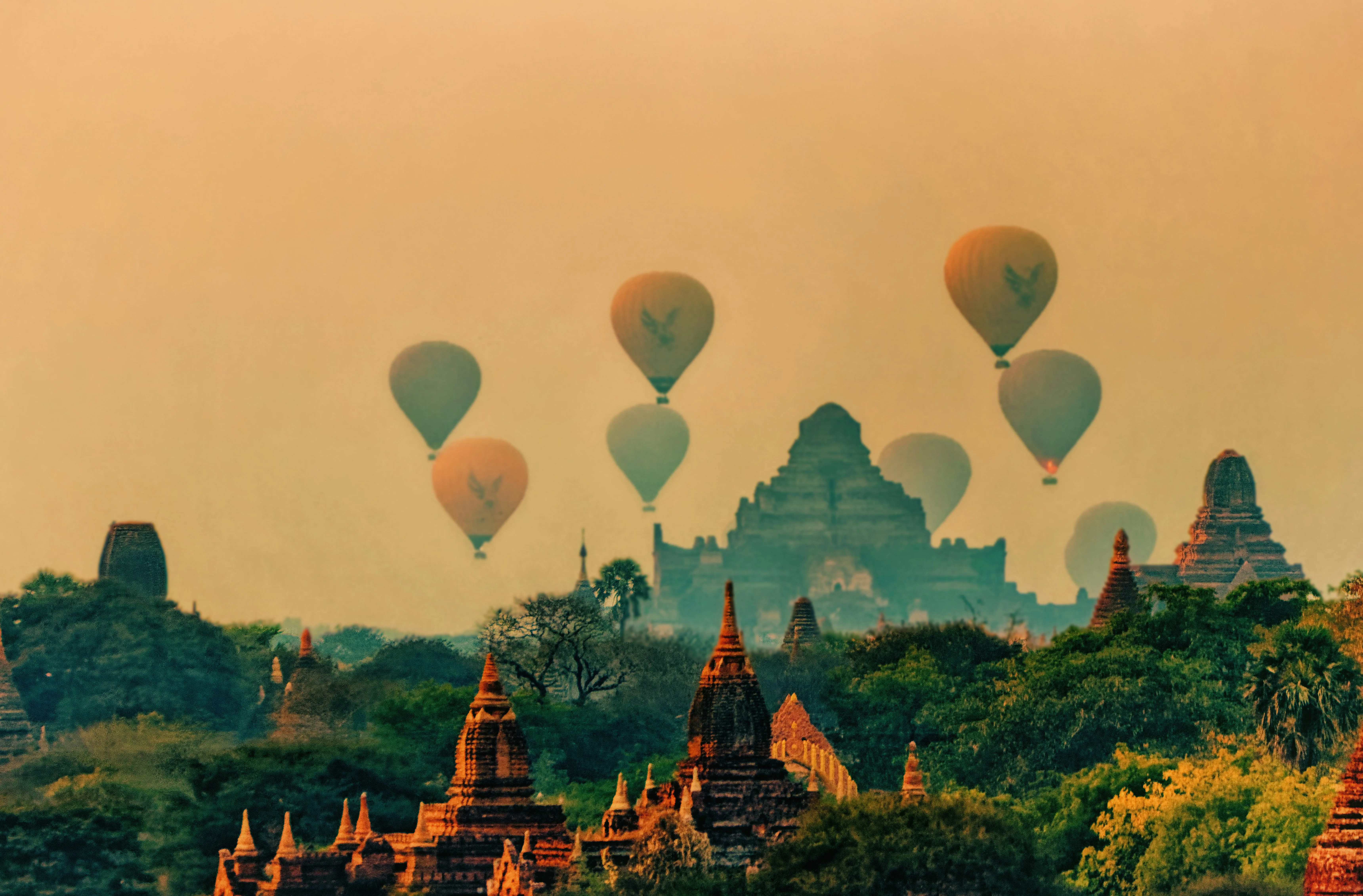 Temples rising above the trees of Bagan at sunrise