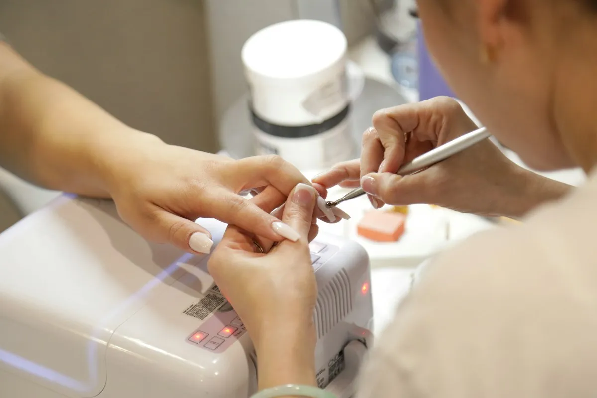 A manicurist painting a client’s nails