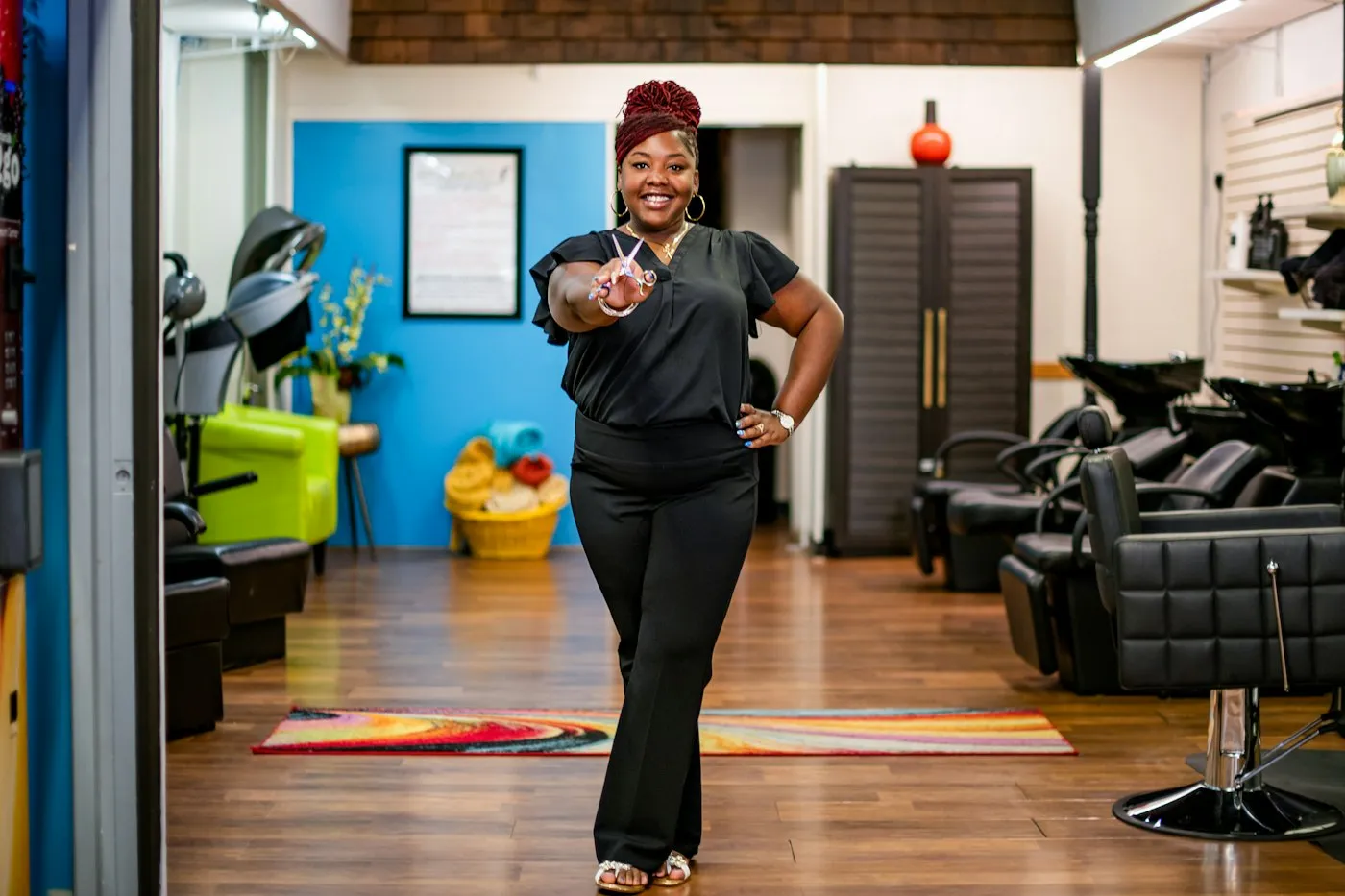 A salon owner smiling on the floor of her salon